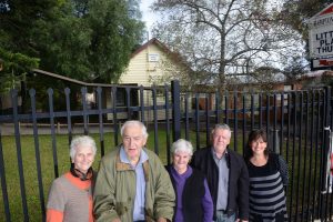 School icon faces bulldozer