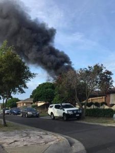 Thick black smoke billows from garage